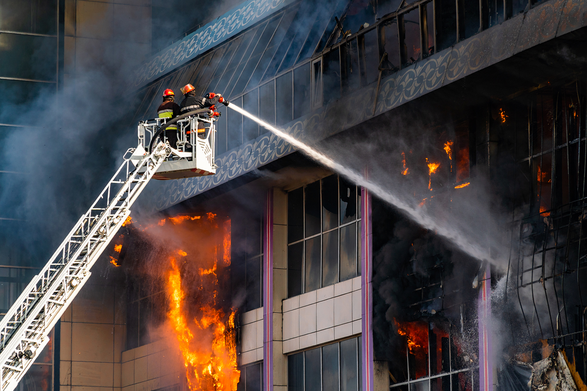 A business on fire being put out by firefighters