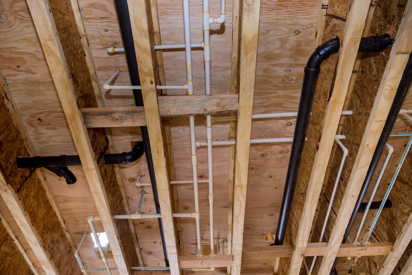Pipes running through an exposed ceiling cavity